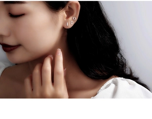 Close-up of a model wearing S999 sterling silver letter I DO minimalist stud earrings