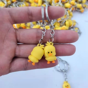 Cute yellow cartoon duck soft PVC keychain pendant with metal ring held in hand