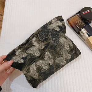 Nahaufnahme der Vintage Kosmetiktasche aus schwarzem Stoff mit goldener Schmetterlingsstickerei