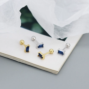 Macro shot of gold and silver rectangle blue zircon stud earrings with screw back design