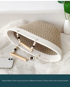 Detail of woven tote bag with wooden bead handle and cotton rope texture on a sofa