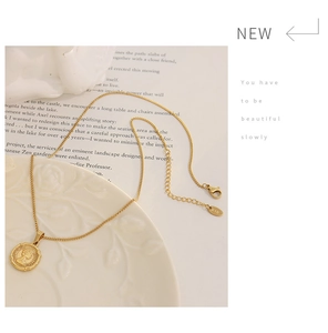 Macro detail of gold coin pendant with queen relief, K18 stamp, and cross chain