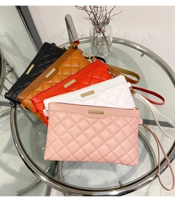 Quilted diamond clutch bags in black, brown, red, white, and pink on a glass table