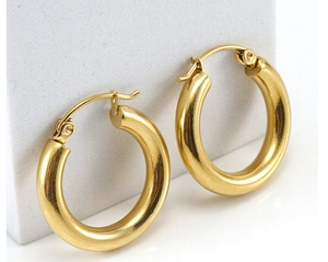 Vista macro de pendientes de aro de acero inoxidable dorado de 18K con detalle de cierre