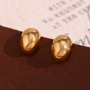 Macro di orecchini a fagiolo in oro con finitura a specchio su base di legno scuro