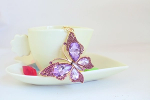Detailed close-up of a purple crystal butterfly keychain with sparkling rhinestones
