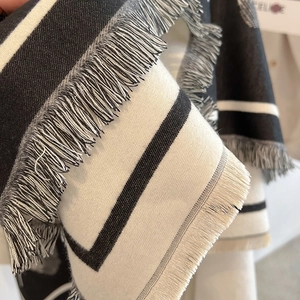 Close-up of black and white striped ginkgo leaf scarf with soft fringe tassel detail