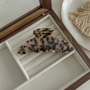 Detail shot of a large leopard acetate hair claw with FRANCE Handmade engraving in a box