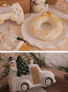 Detailed close-up of cream-white Christmas ornaments on a white lace fabric background