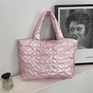 Detail of pink quilted tote bag with heart patterns and Sozakka woven label for storage