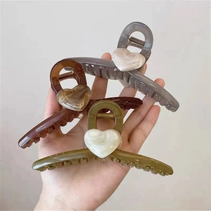 Three elegant marble textured heart hair claws in grey, amber, and olive green resin