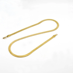 Close-up of a flat golden snake bone chain necklace with high-gloss metallic finish