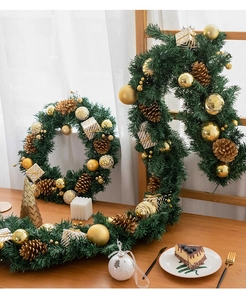 Christmas garland and wreath set with pine cones and golden ornaments on wooden table