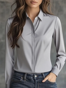 Detail of grey satin long sleeve shirt showing smooth silk-like texture and classic lapel