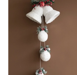 Detail of white glitter Christmas bells with pine cones and red berries on a string