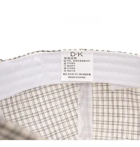 Detail view of cotton plaid baseball cap interior showing white sweatband and care label