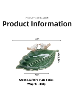 Macro detail of leaf-shaped ceramic jewelry tray in dark green with 3D bird accents