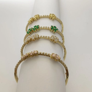 Detailed display of clover bracelets with yellow, green, white and pink gemstones