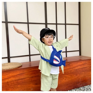 Blue shark cartoon kids chest bag shown on model with adjustable strap detail