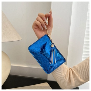 Close-up of blue crocodile pattern clutch featuring a gold chain and elegant blue tassel