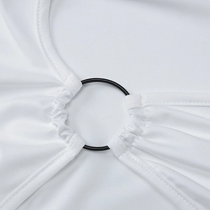 Detail of white dress with black metal ring fastener and gathered ruched fabric texture