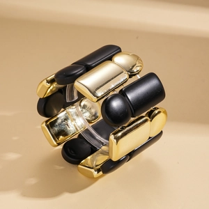 Detail of wide stretch bracelet with polished gold and matte black geometric acrylic blocks