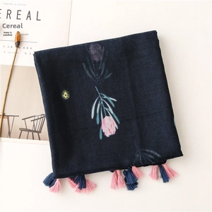 Detail of navy cotton-linen scarf with pink floral patterns and fringe tassels