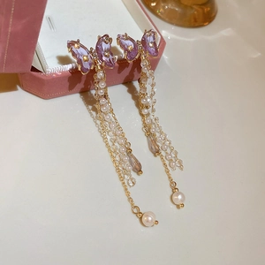 Detail of purple butterfly tassel earrings with pearls and crystal on jewelry box