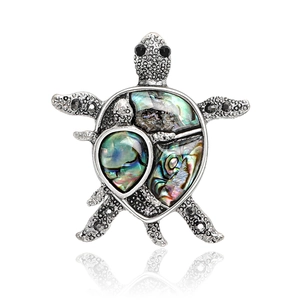 Detailed view of turtle brooch with iridescent abalone shell and black rhinestones