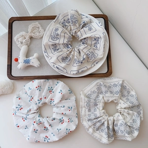 Detailed macro view of cotton floral scrunchies in three pastoral print patterns