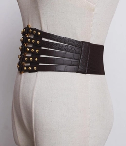 Detail of dark brown faux crocodile waist belt with five gold buckles and rivet accents