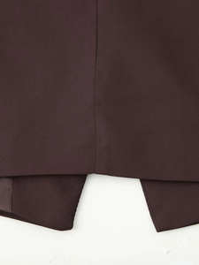 Close-up of deep brown twill fabric blazer showing back vent detail and stitching