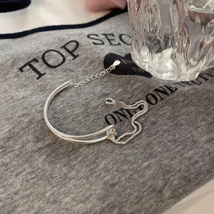 Detail of silver double-layer bracelet with rigid rings, soft chains, and lobster clasp