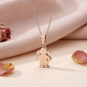 Detail of rose gold girl silhouette pendant necklace on silk with rose petals