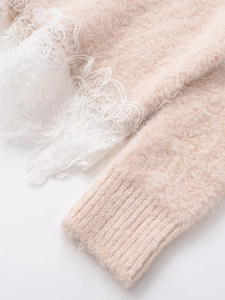 Detail of soft pink knit sweater featuring fuzzy mohair texture and white lace cuffs