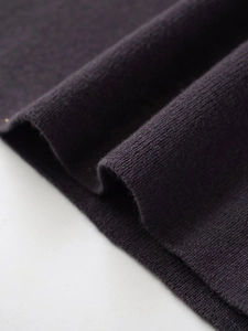 Macro shot of dark purple knitted fabric detail with soft texture and ribbed pattern