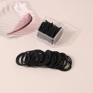 Detailed view of durable black spiral hair ties with a clear acrylic storage box
