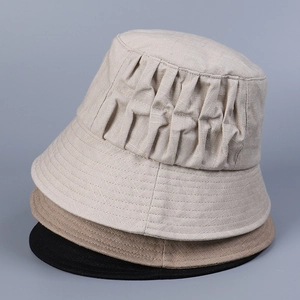 Close-up of pleated linen sun hats in beige, khaki, and black with fine stitching details