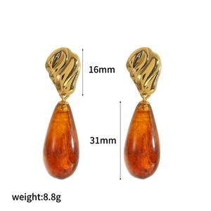 Detail view of teardrop resin earrings with 16mm gold studs and 31mm amber pendants