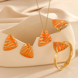 Golden jewelry set with orange enamel triangle necklace, earrings, ring, and cuff bracelet
