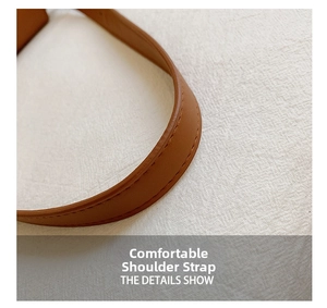Detail of comfortable brown leather shoulder strap with fine stitching on a modern bag