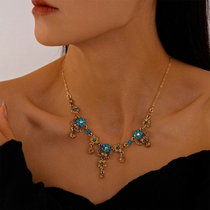 Detail of vintage gold necklace with blue and champagne floral crystals on model