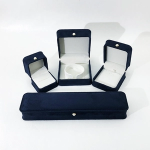 Detail of dark blue velvet jewelry box set with white satin lining and pearl clasp decoration