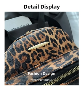 Detail of leopard print backpack with gold metal hardware and black zipper teeth