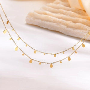 Detail of gold double-layered titanium steel necklace with square and teardrop pendants