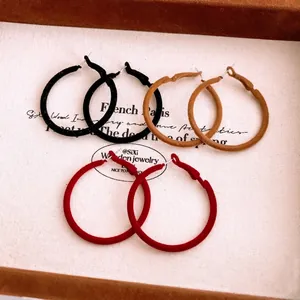 Three pairs of vintage-style flocked round hoop earrings in black, brown, and red colors