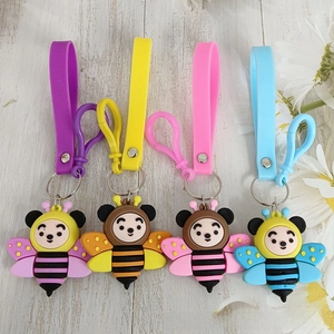 Close-up of four colorful silicone bee keychains with matching lanyards on wood