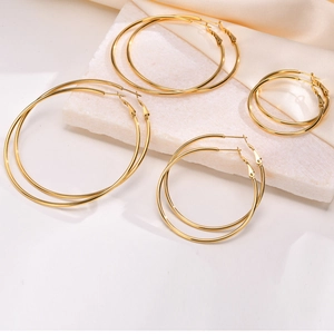 Set of four sizes of gold stainless steel hoop earrings on elegant silk and stone