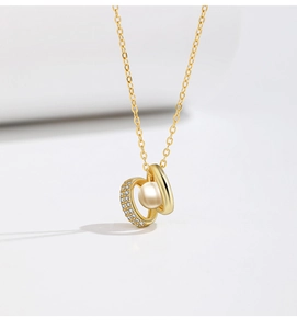 Detail of gold necklace with zircon-studded double rings and floating freshwater pearl