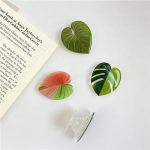 Detailed close-up of acrylic leaf-shaped phone grips in green and pink gradient colors
